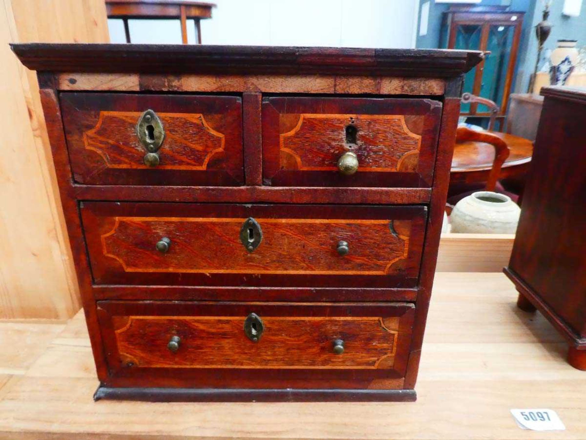 An apprentice chest of two short over three long graduated drawers, the mahogany body with satinwood