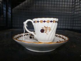 A 19th century tea cup and saucer dish, gilt decorated with a band of stylised blue flowers,