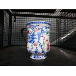 A Chinese Export mug of oversized proportions decorated with figures at leisure within blue and