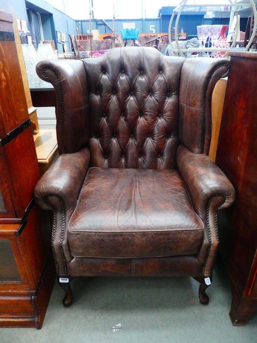 Brown button back wing back armchair