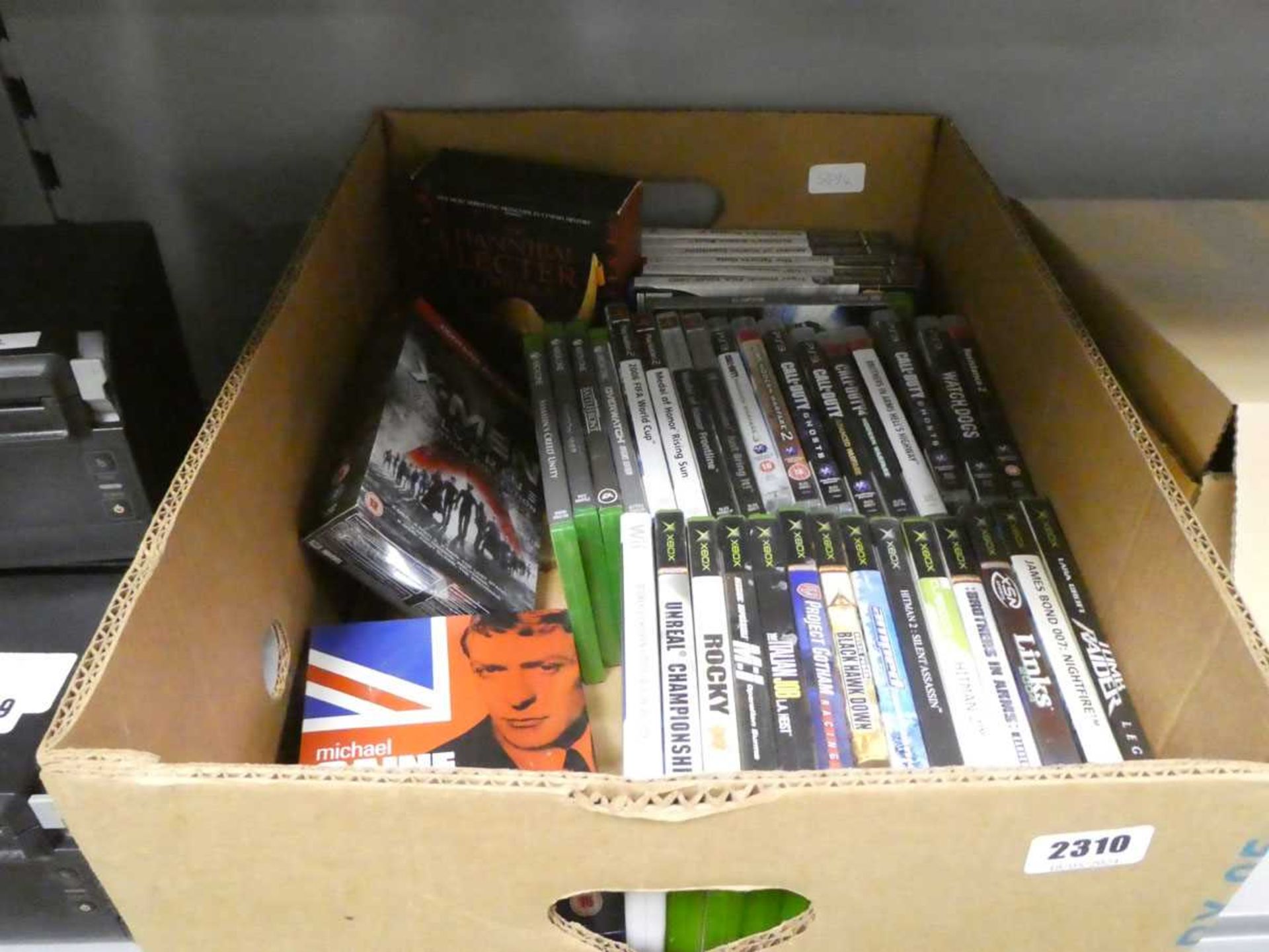 Box containing games for PS2, XBox One, PS3, Wii, and DVDS