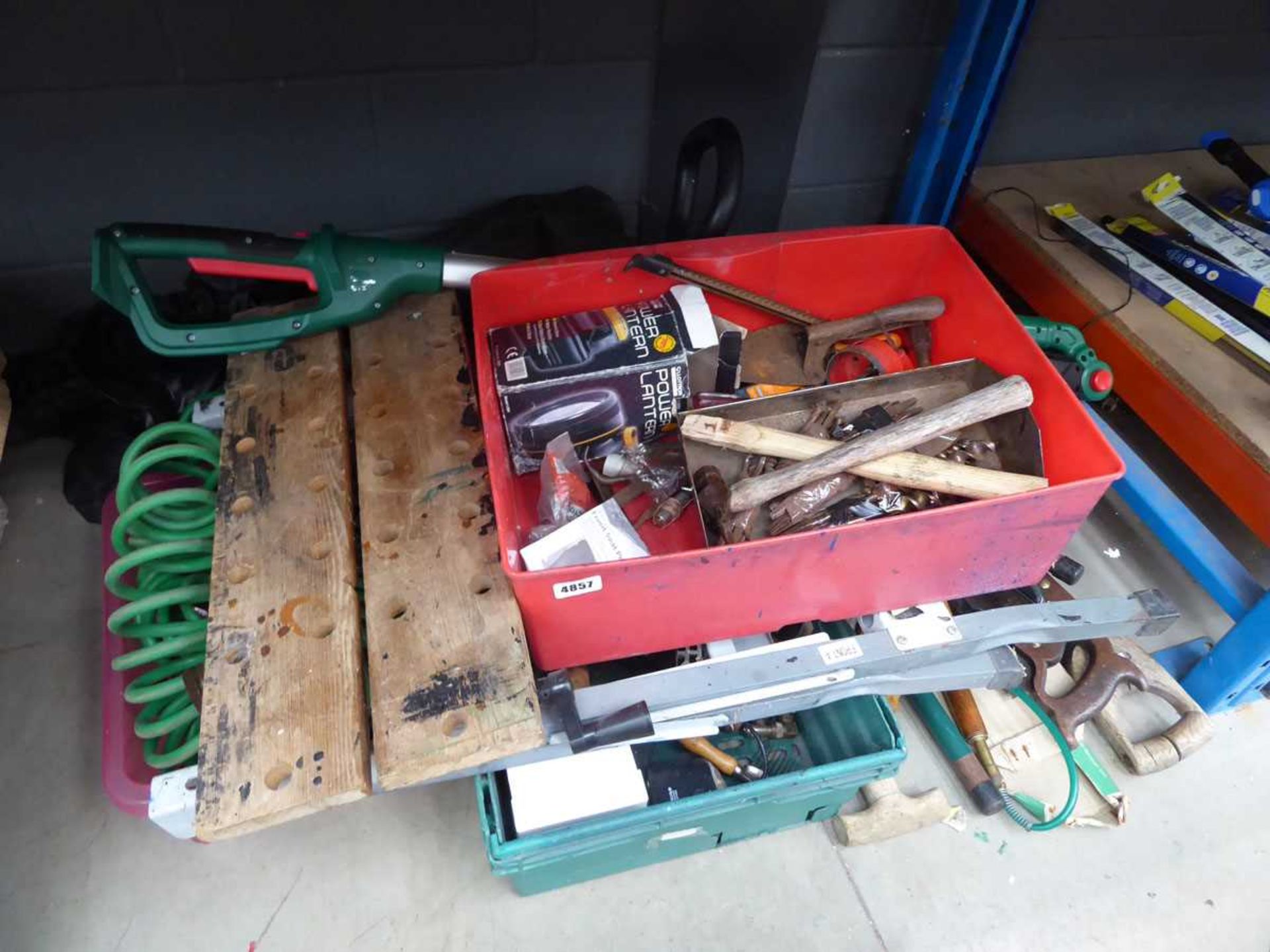 1/4 of an underbay containing tools, workbench, saws, strimmer etc.