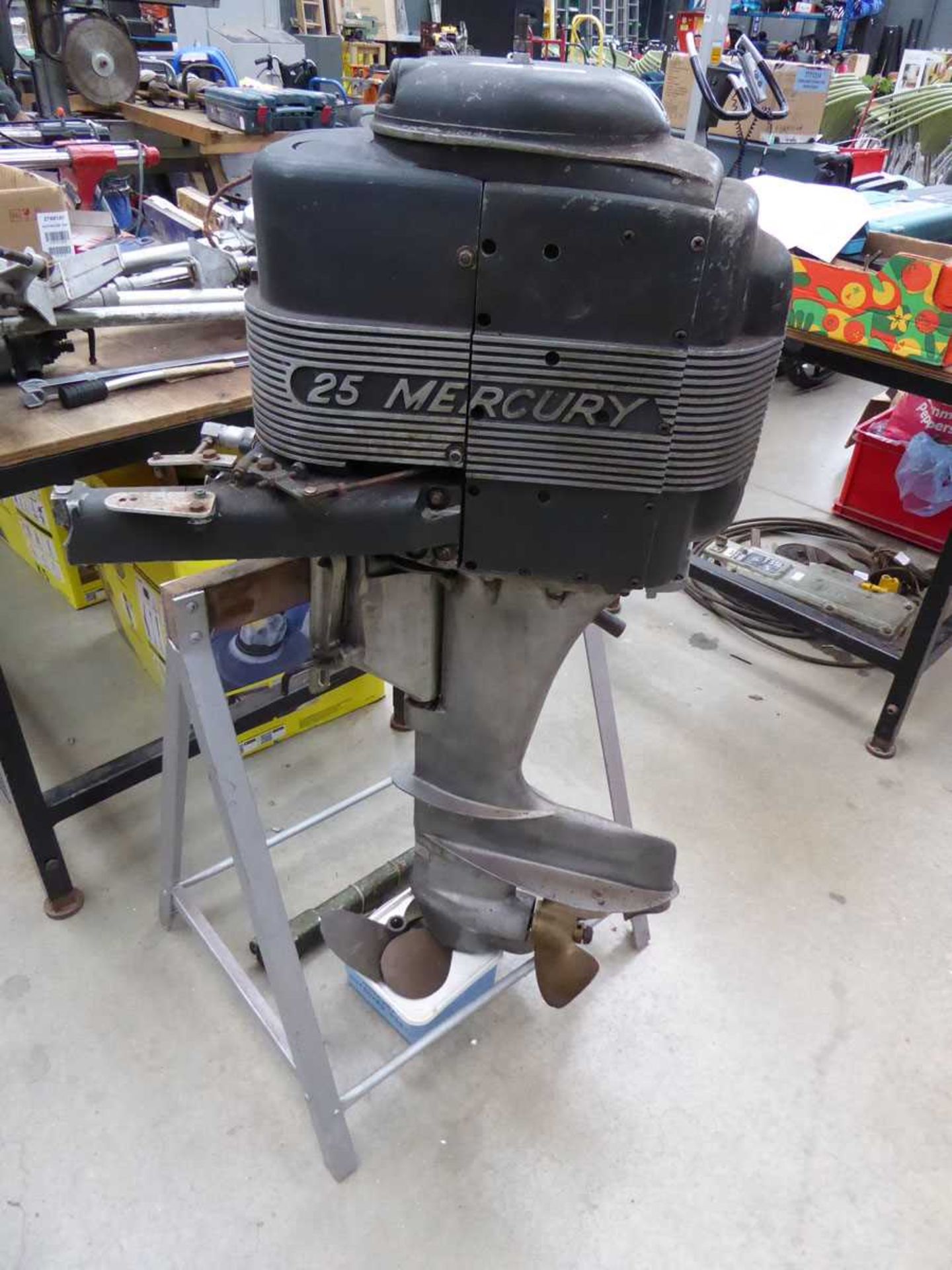 Mercury 25 petrol powered outboard motor on stand