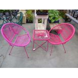 2 assorted coloured pink chairs and a pink glass topped table