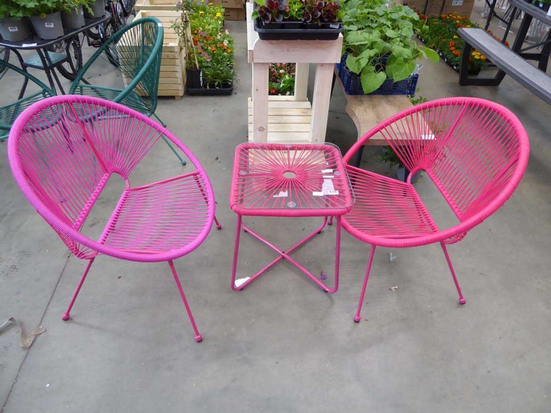 2 assorted coloured pink chairs and a pink glass topped table