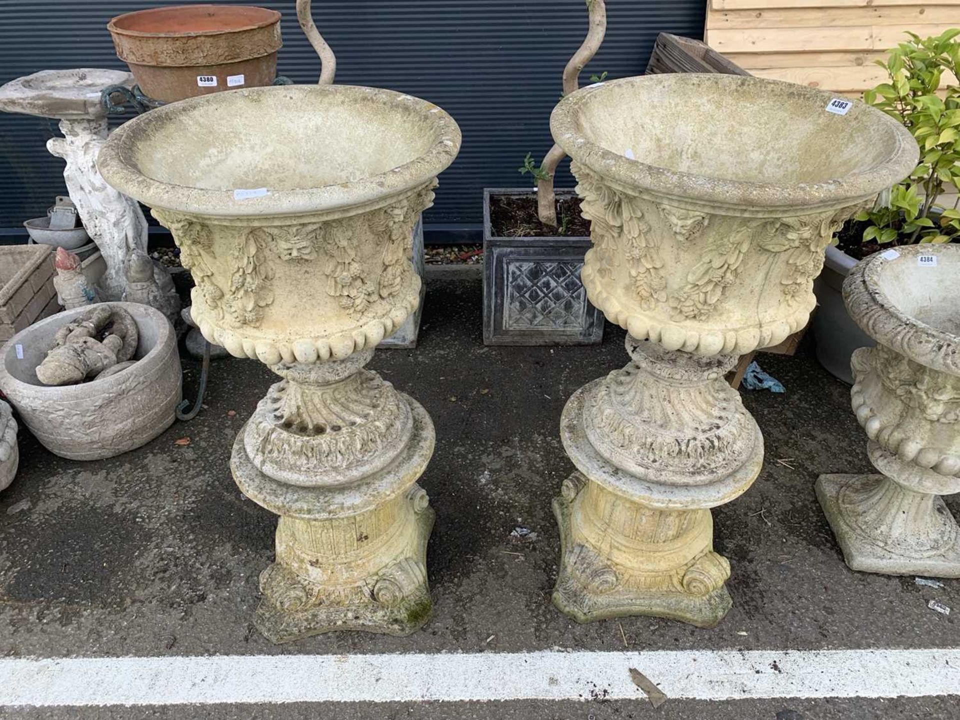 Pair of large ornate concrete planters on stands