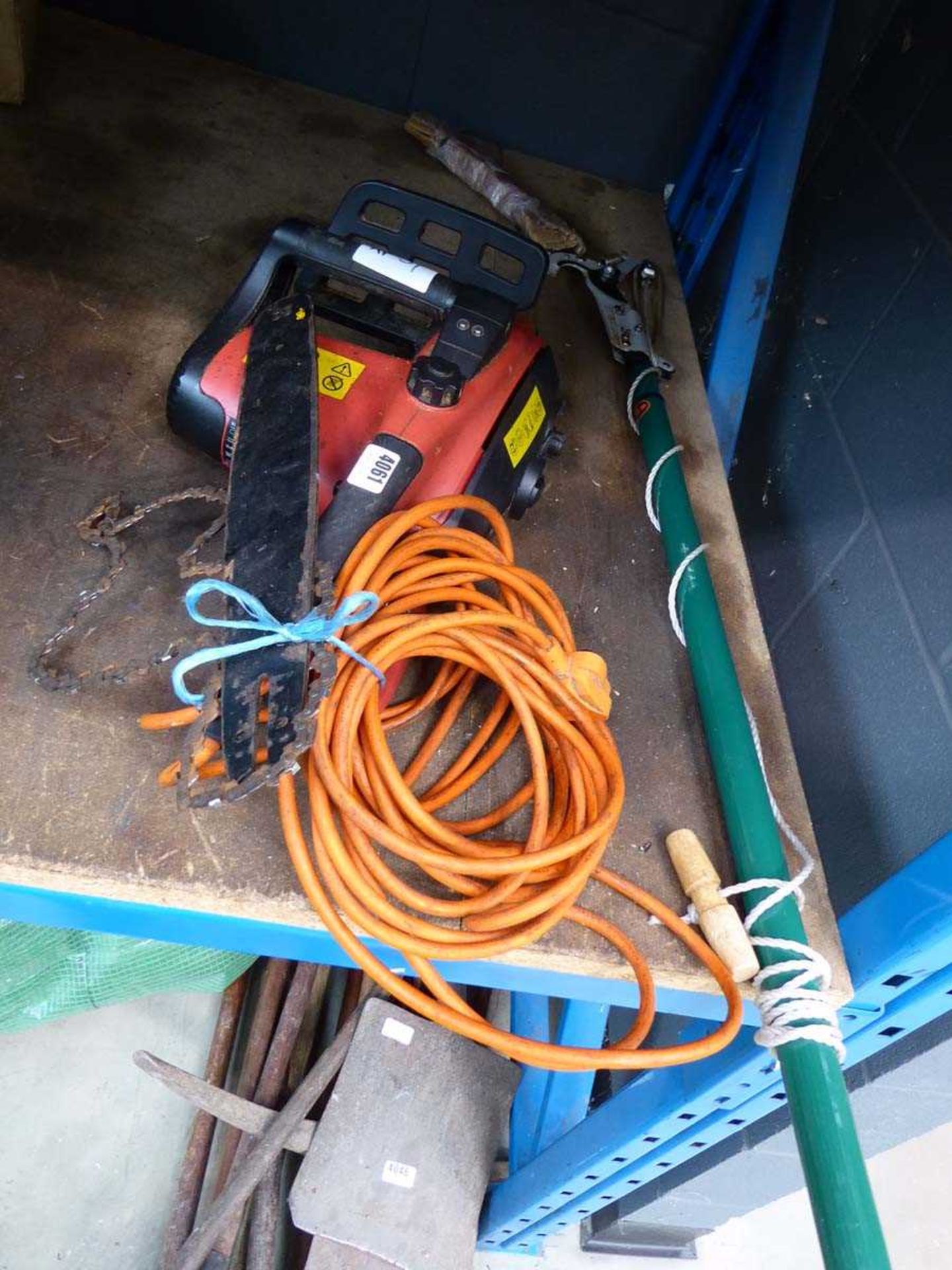 Red electric chainsaw, bar and chain unattached plus a pole saw