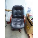 Worn swivel armchair with wooden arms