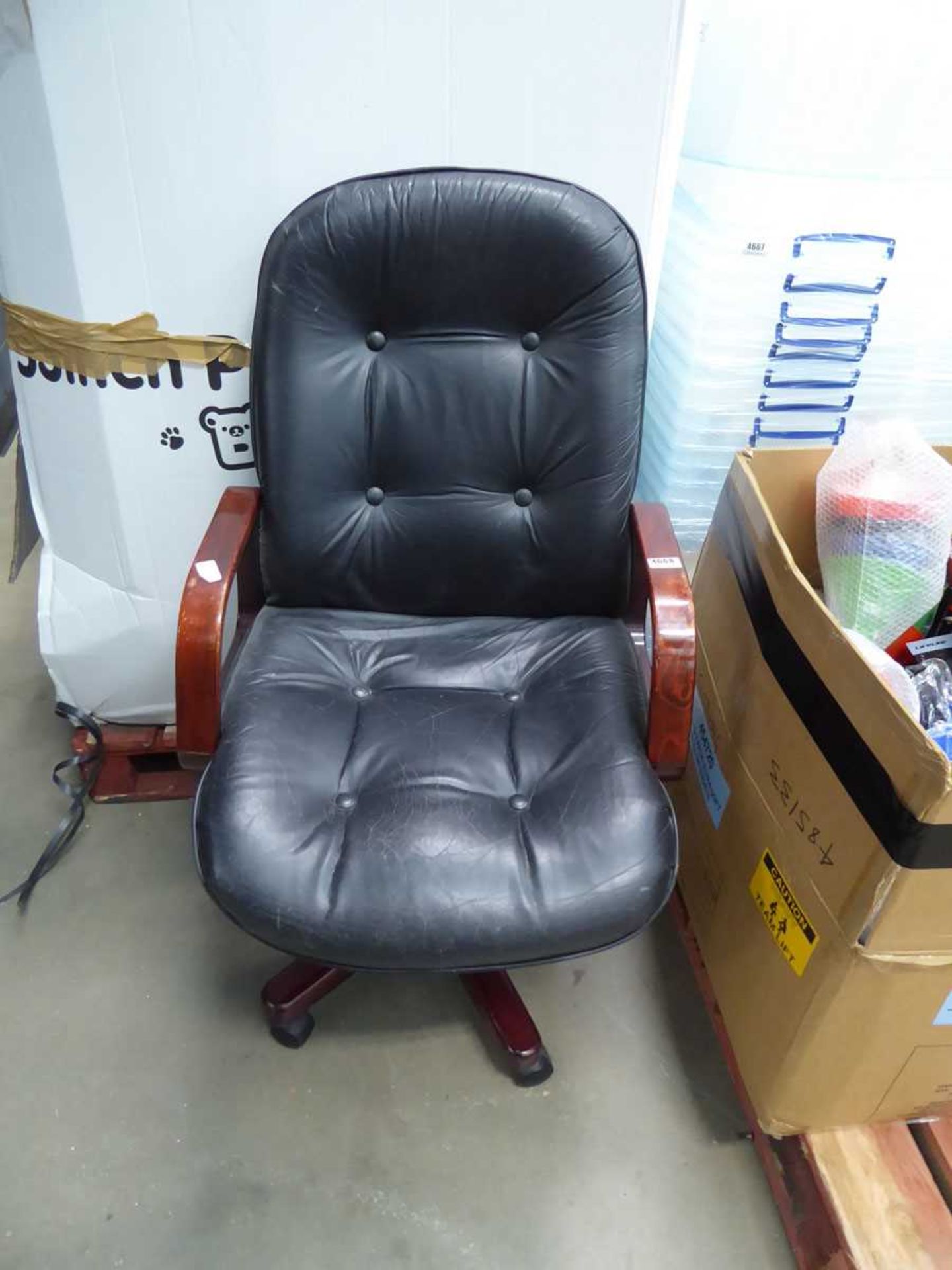 Worn swivel armchair with wooden arms