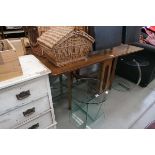 Oak effect gateleg dining table, together with four black vinyl chairs (sold as a collectors item)