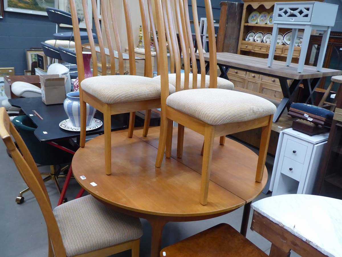 Circular teak extending dining table on tapered supports with 4 matching chairs with brown