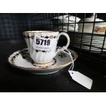 A 19th century tea cup and saucer dish, gilt decorated with a band of stylised blue flowers,