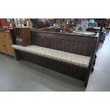 Dark wood pew with floral cushion