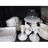 Cage containing white china to include gravy boats, cake stands, large mugs, candlesticks