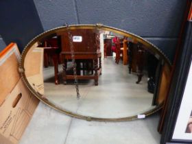 Oval bevelled mirror in brass frame