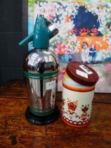 Soda syphon plus a floral patterned tin