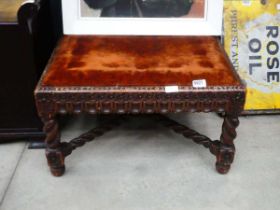 Heavily carved base square footstool with brown upholstery