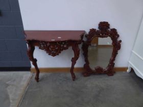 Heavily carved console table with associated mirror