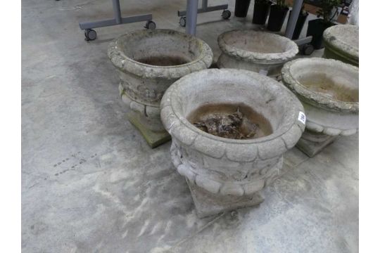 Pair of concrete urn style planters with flower decoration