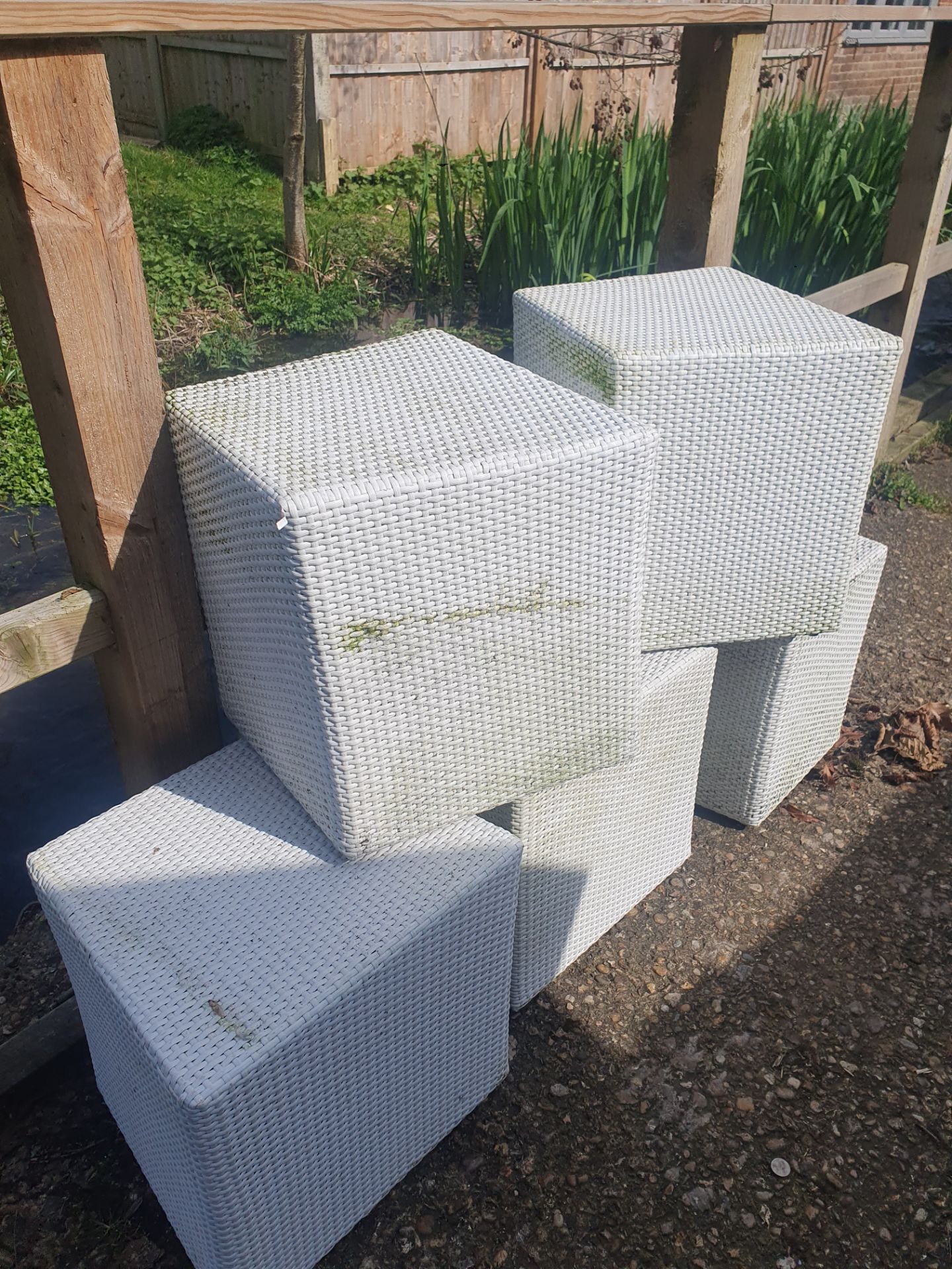 A set of 5 white rattan garden stools