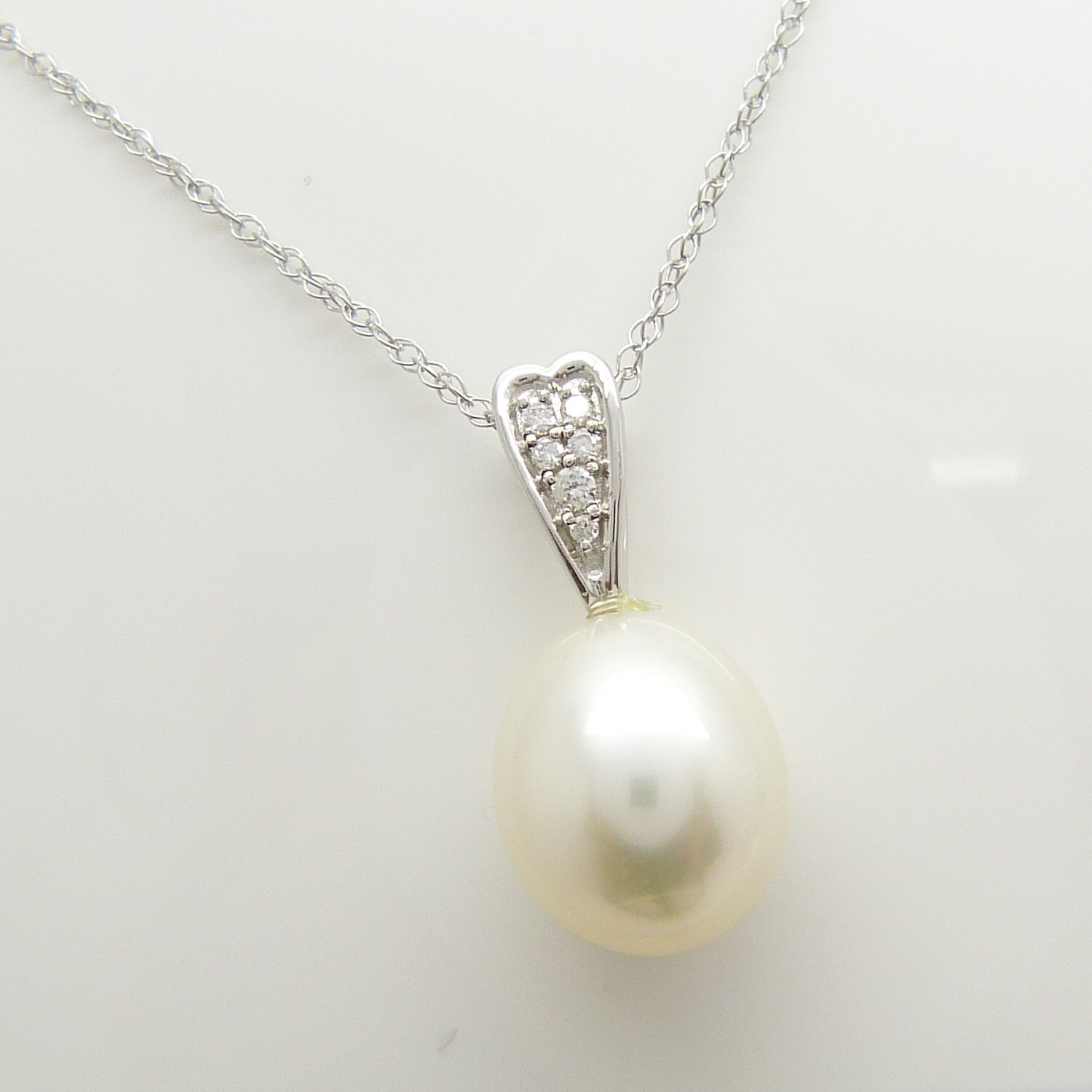 White Gold Necklace. Pendant Features An Oval Cultured Pearl and Diamond-Set Bale