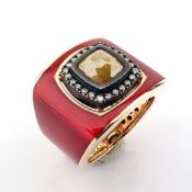 A Luxurious Gold Ring Featuring Red Laser Enamel, Elegantly Adorned With Brilliant Diamonds.