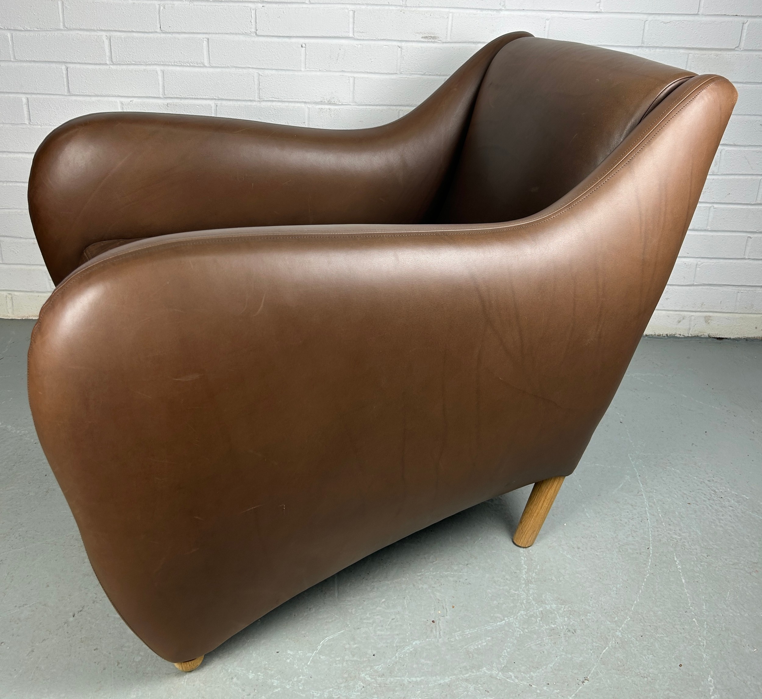 AN SCP BALZAC BROWN LEATHER ARMCHAIR AND FOOTSTOOL BY MATTHEW HILTON, Retailed by the Conran Shop. - Image 6 of 6