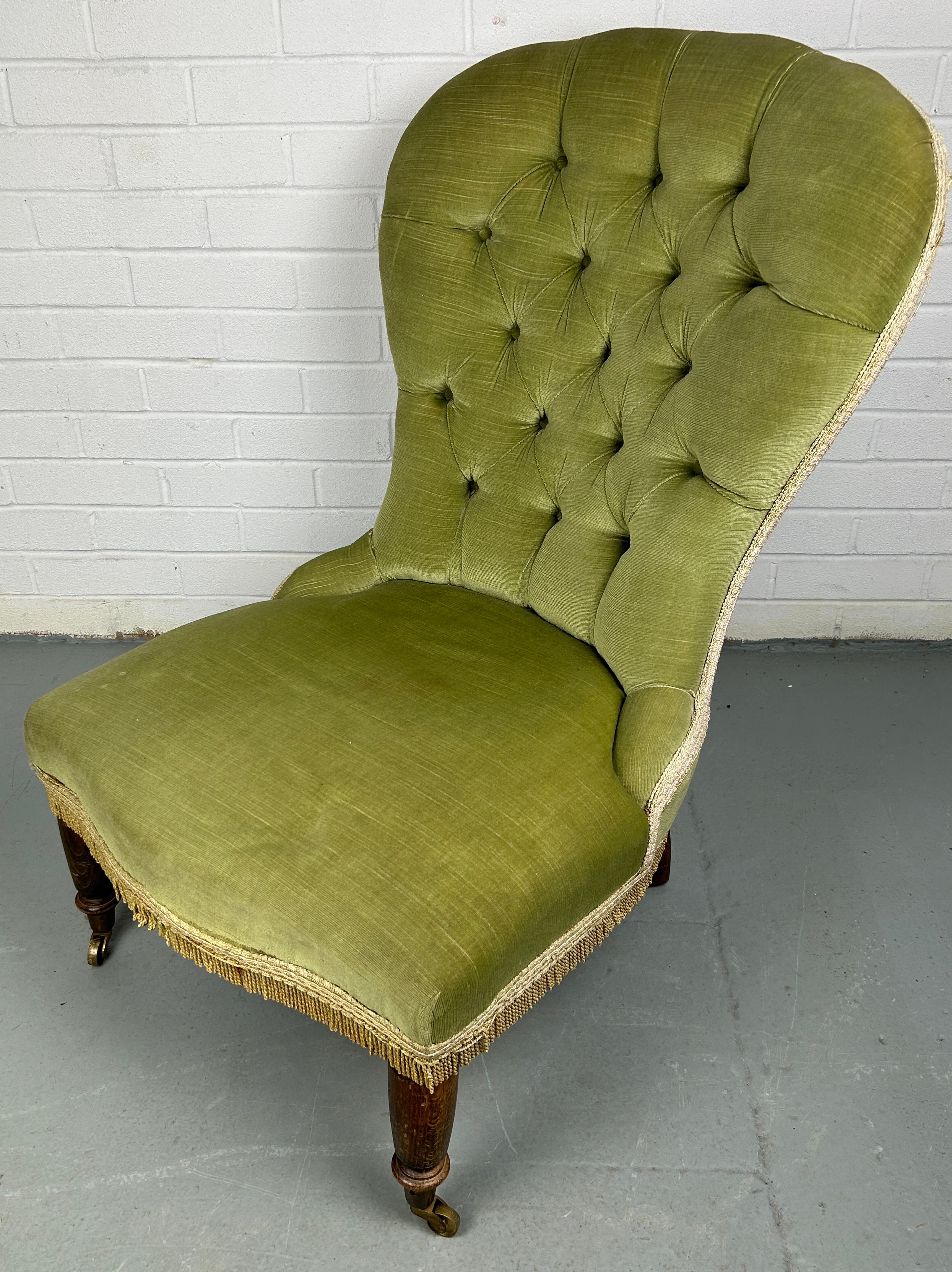 A GREEN EDWARDIAN NURSING CHAIR, on turned legs and castors