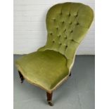 A GREEN EDWARDIAN NURSING CHAIR, on turned legs and castors