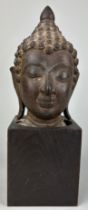 A BRONZE SCULPTURE OF A BUDDHA'S HEAD, Later mounted on a wooden base. The head 17cm. Total height