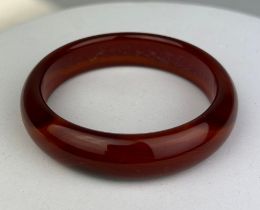 A RED AGATE BANGLE, 55gms