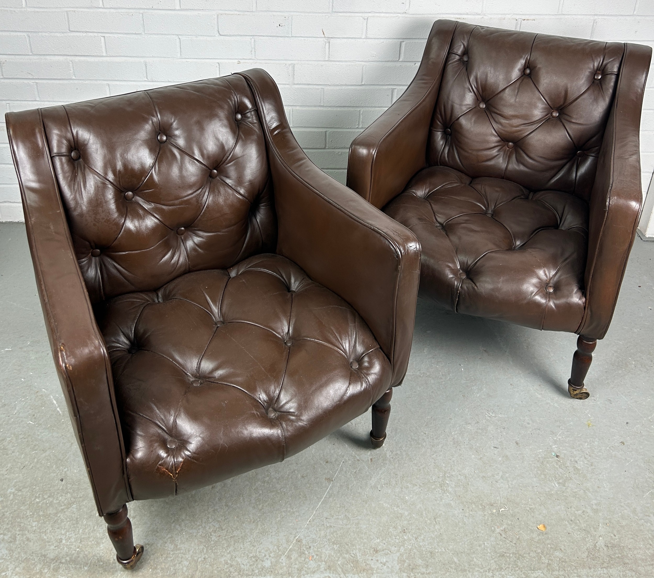 A PAIR OF BROWN LEATHER BUTTON BACK CLUB CHAIRS, Removed from Brown's Club London. Each raised on