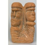 A TERRACOTTA RED STONE ANCESTRAL PLAQUE DEPICTING MALE AND FEMALE CARVED HEADS Possibly ancient,