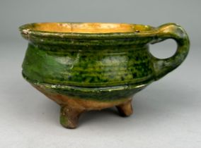 A EUROPEAN CERAMIC BOWL WITH HANDLE ON TRIPOD FEET PROBABLY 16TH CENTURY Found in a Dutch canal,