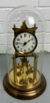 A GERMAN BRASS CLOCK MOUNTED UNDER A GLASS DOME, 30cm H