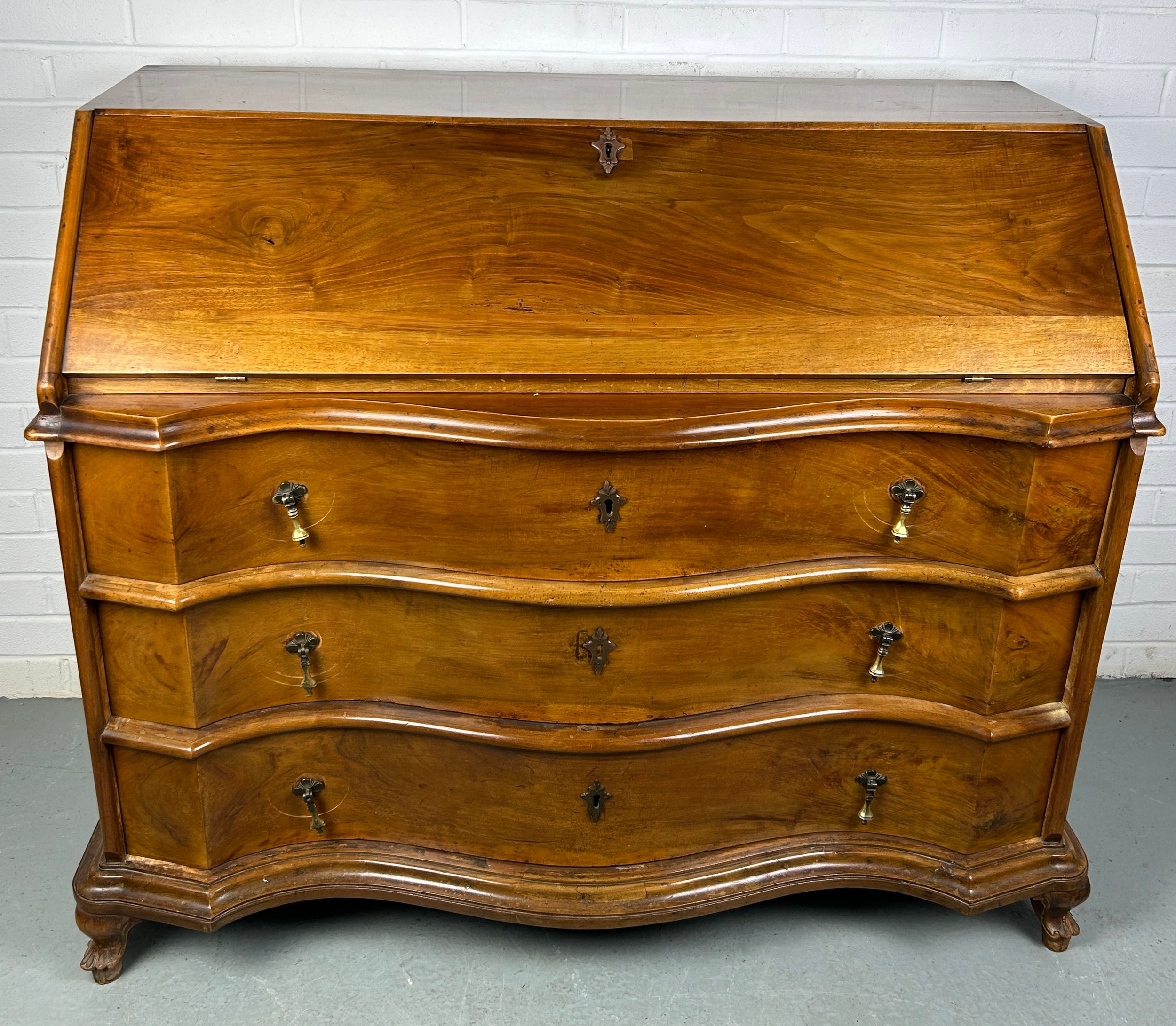 A CONTINENTAL WALNUT SERPENTINE BUREAU, 116cm x 108cm x 58cm Early 20th century, with fall front