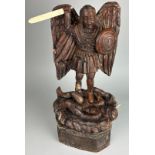 A OAK CARVED FIGURE OF ST MICHAEL SLAYING THE DEVIL, With bone sword and horns. Probably 19th