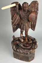 A OAK CARVED FIGURE OF ST MICHAEL SLAYING THE DEVIL, With bone sword and horns. Probably 19th