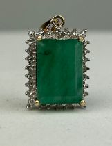 A NATURAL NO HEAT EMERALD PENDANT SET IN GOLD AND SURROUNDED BY SMALL DIAMONDS, Weight 4.0gms. 2.5cm