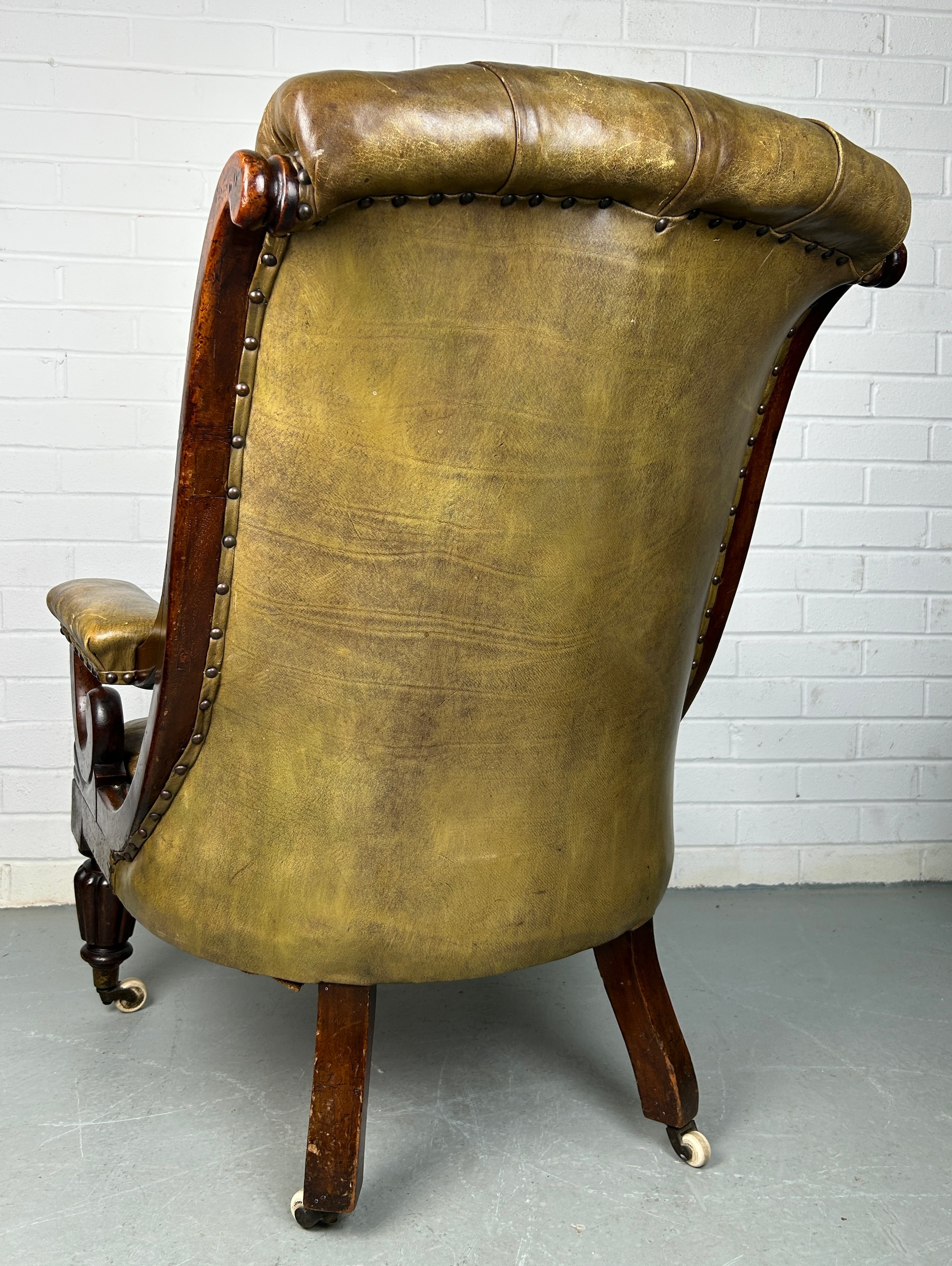 A VICTORIAN LIBRARY GREEN LEATHER UPHOLSTERED SLIPPER ARMCHAIR, Raised on four legs and castors. - Image 2 of 3