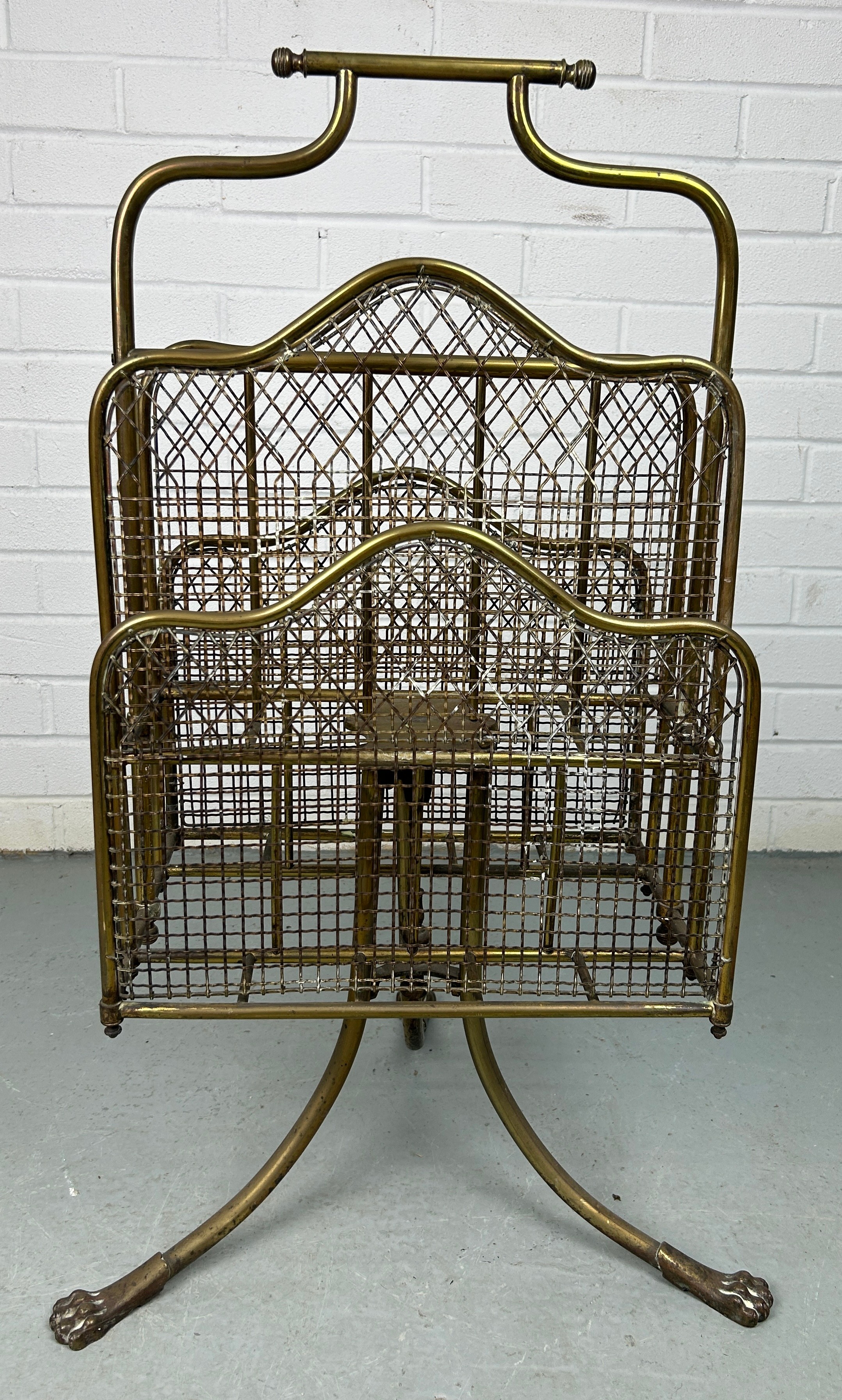 AN EARLY 20TH CENTURY REVOLVING BRASS MAGAZINE RACK WITH LION PAW FEET, 80cm x 40cm x 26cm