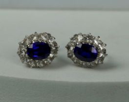A PAIR OF WHITE METAL EARRINGS WITH BLUE STONES AND POSTS MARKED 9CT,