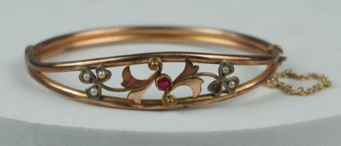 A 9CT GOLD ANTIQUE BRACELET WITH CUT FLORAL DESIGN SET WITH SEED PEARLS AND A GARNET, Weight 9.2gms