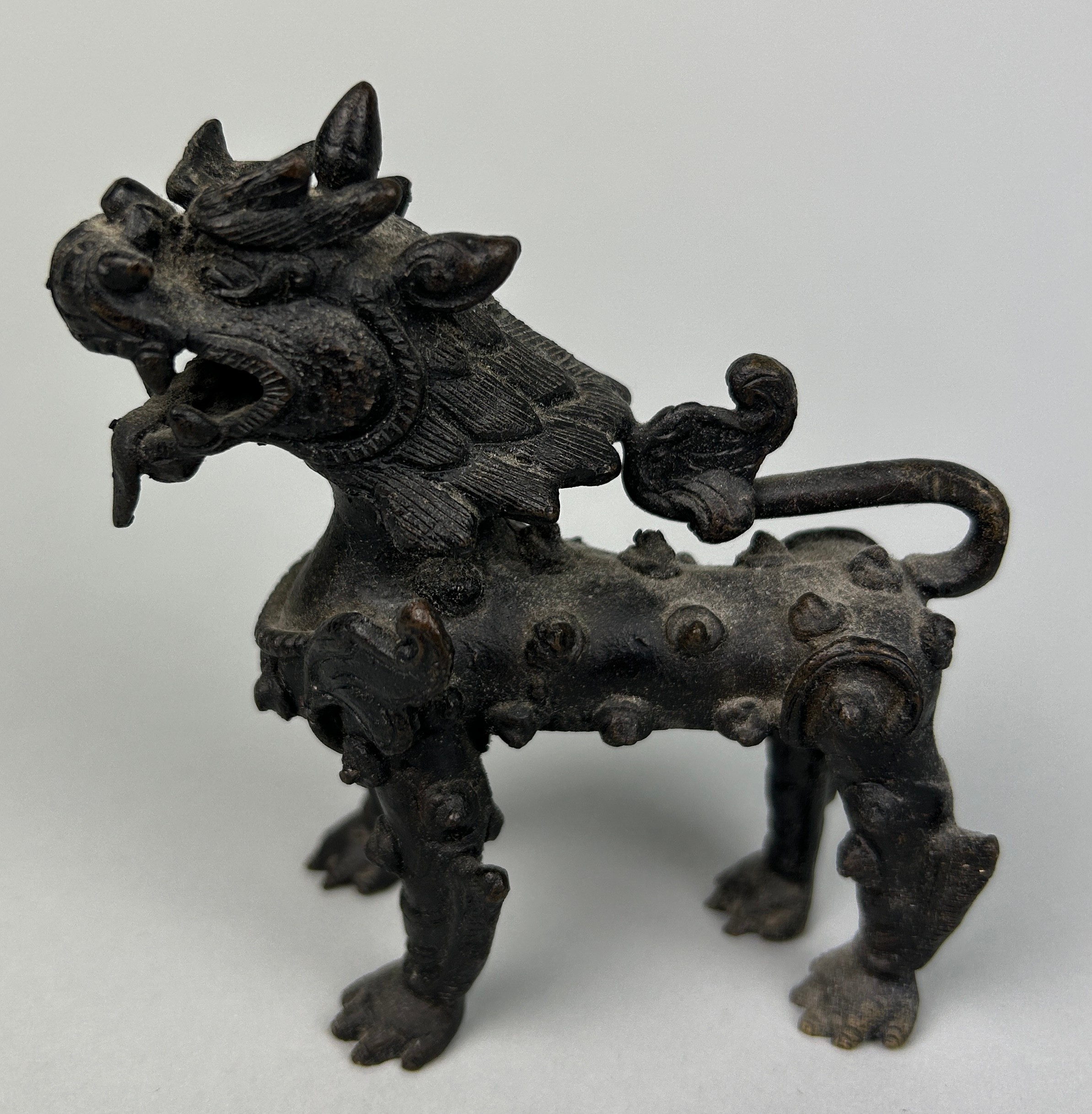 A CHINESE BRONZE FIGURE OF A LION, 9cm x 9cm