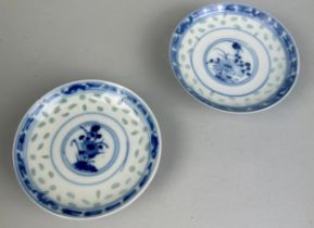 A PAIR OF 20TH CENTURY CHINESE FOOTED DISHES WITH CENTRAL CIRCULAR PANEL DECORATED WITH FLOWERS, 9cm
