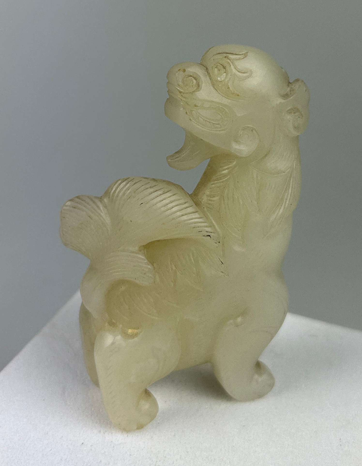 AN EARLY 19TH CENTURY CHINESE WHITE JADE GROUP OF A LION, 7.5cm x 4.7cm x 1.8cm