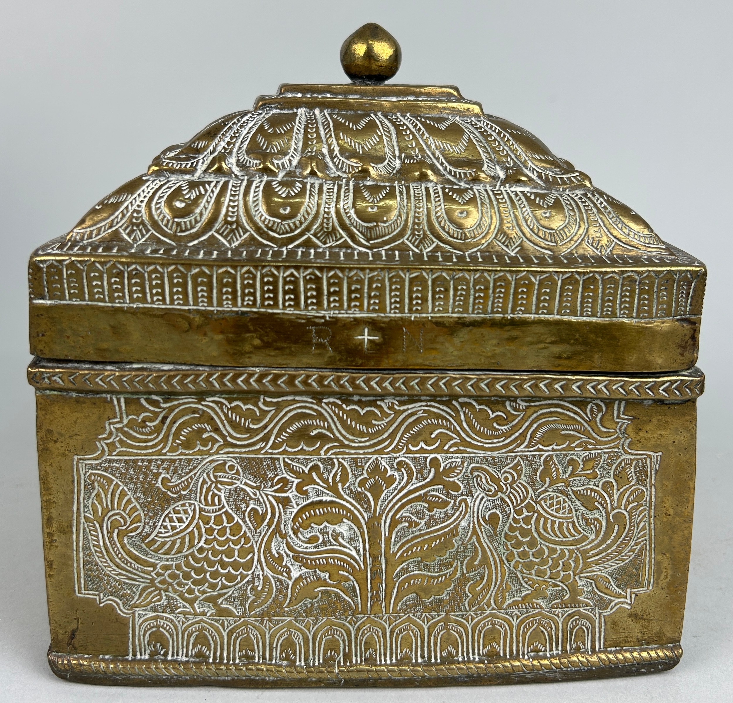 A 19TH CENTURY BRASS CASKET POSSIBLY INDIAN OR KHAJAR DECORATED WITH PEACOCKS AND FOLIAGE, 17cm x
