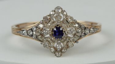 A FINE 14CT GOLD BANGLE WITH CENTRAL CLAW SET SAPPHIRE SURROUNDED BY DIAMOND CLUSTERS, Multi