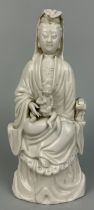 A 19TH CENTURY CHINESE BLANC DE CHINE FIGURE OF A SEATED GUANYIN WITH CHILD,