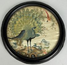 A 19TH CENTURY CHINESE CIRCULAR SILK PANEL DEPICTING A PEACOCK AMONGST FOLIAGE, 15cm in diameter